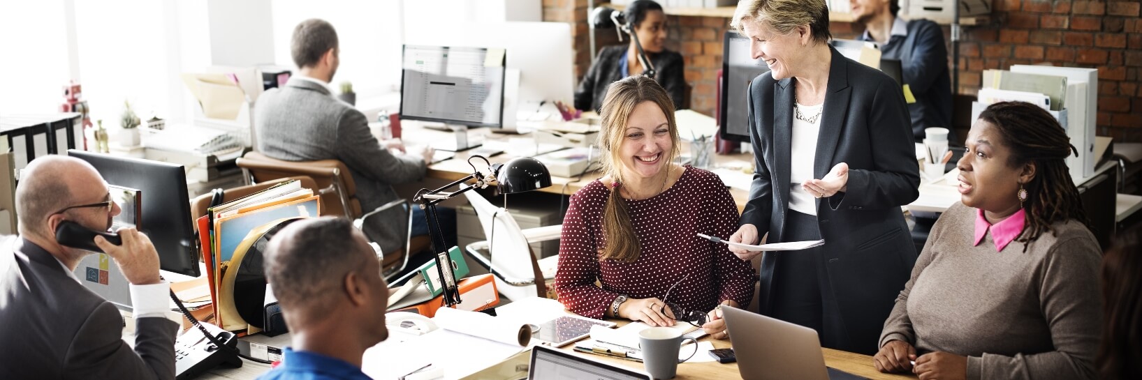 employees working in a small office smiling