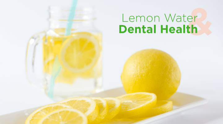 glass of water with sliced lemons in it with a sliced lemon sitting next to it