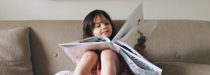 girl reading tooth fairy books on the couch