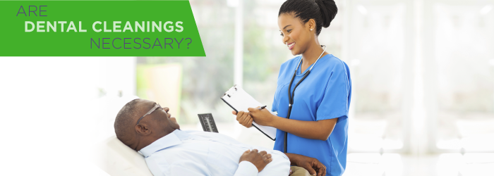 dentist cleaning man's teeth