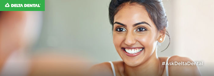 woman smiling in the mirror admiring her white teeth