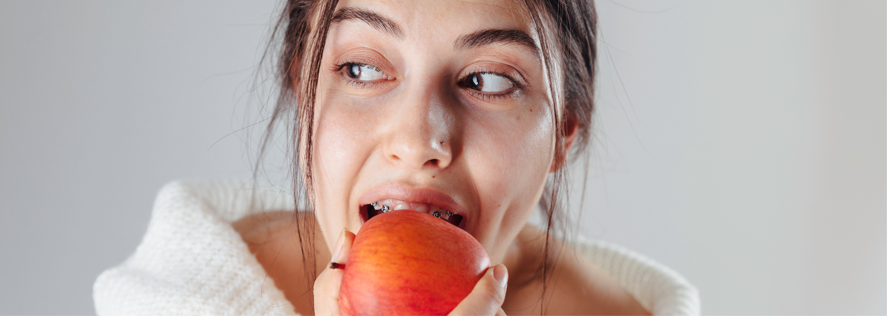 girl with braces eating an apple