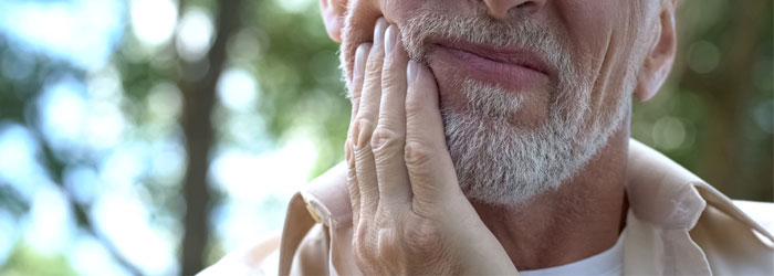 man holding jaw in pain