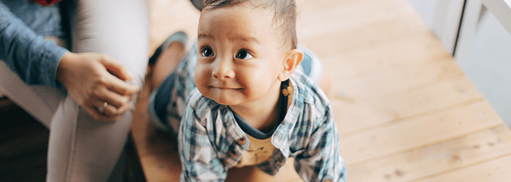 infant boy looking up and smiling