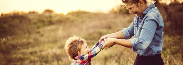 mother and son playing in flower field