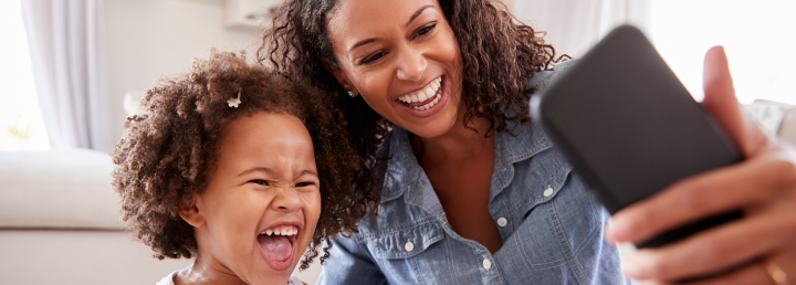 mom and daughter smiling at phone