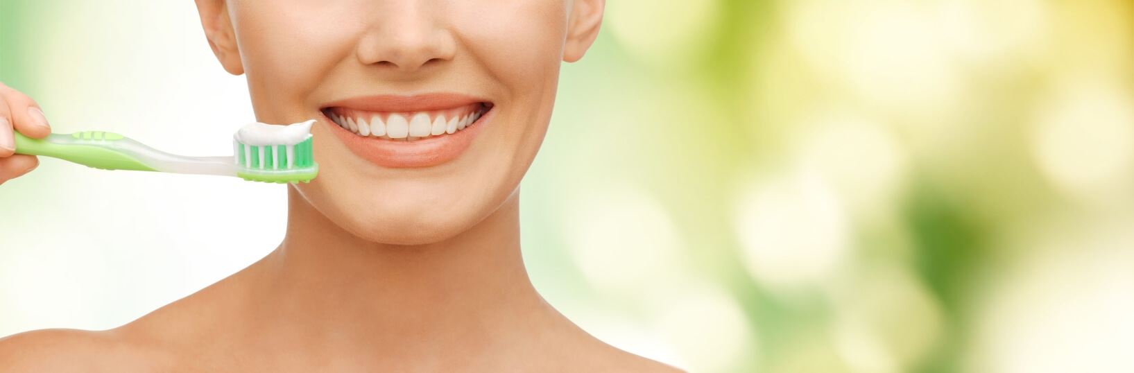 woman holding toothbrush with toothpaste on it