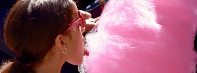 girl eating big pink cotton candy