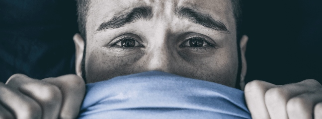 man covering his mouth with blue sheet
