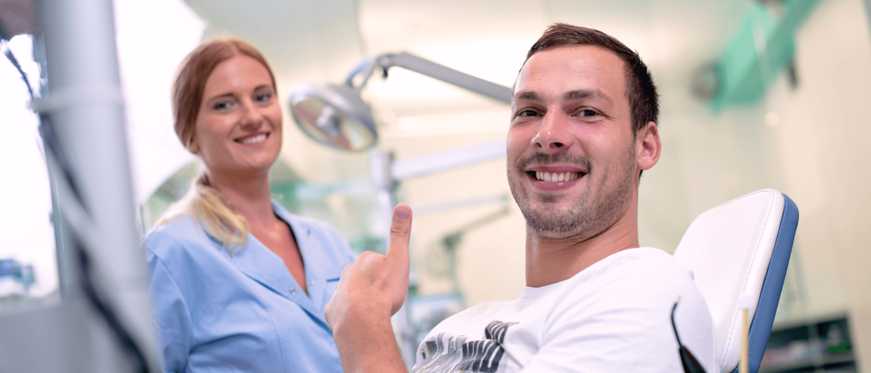man at dentist giving thumbs up in chair