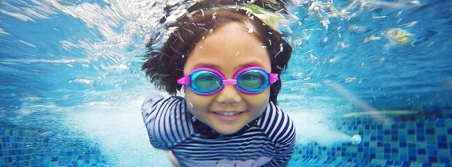 Girl swimming in a pool with goggles