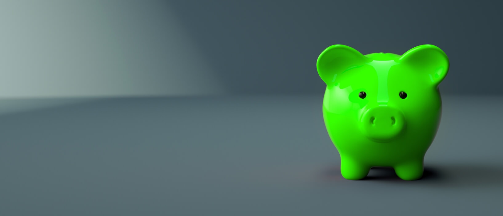 green piggy bank sitting on gray background