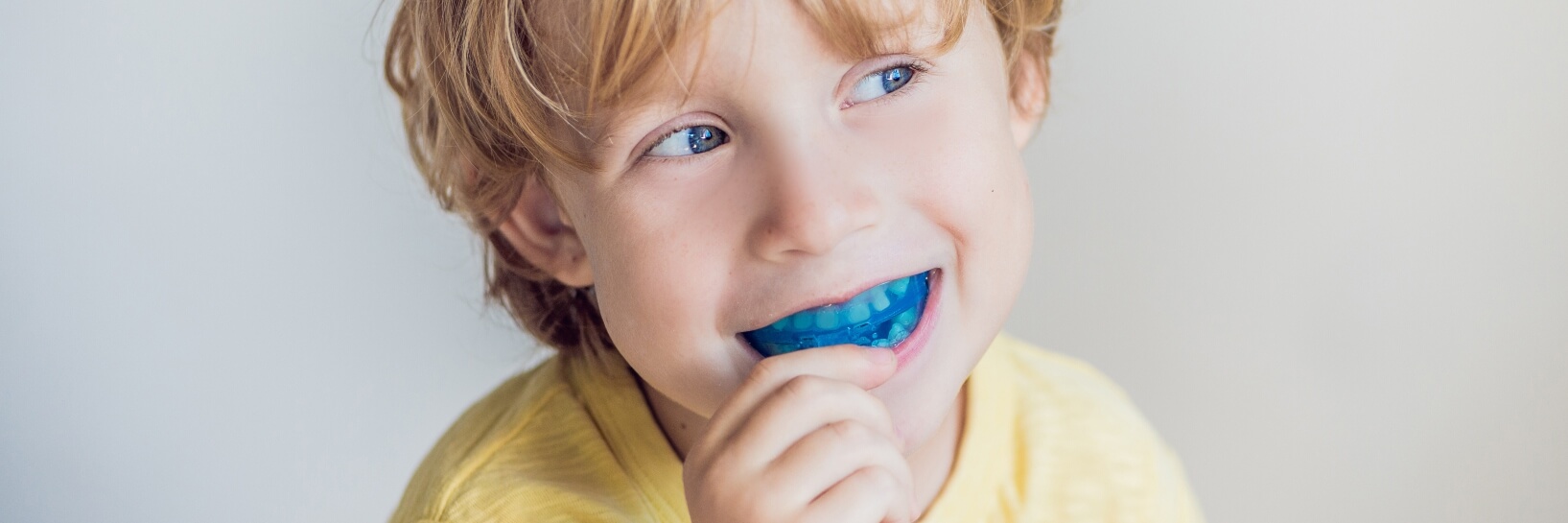 boy with blue mouthguard in his mouth