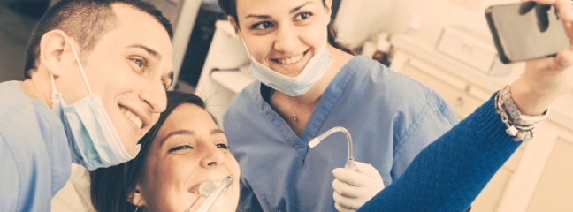 girl taking a selfie with her dentist and dental hygenist