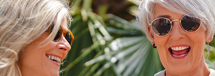 two senor women wearing sunglasses and laughing