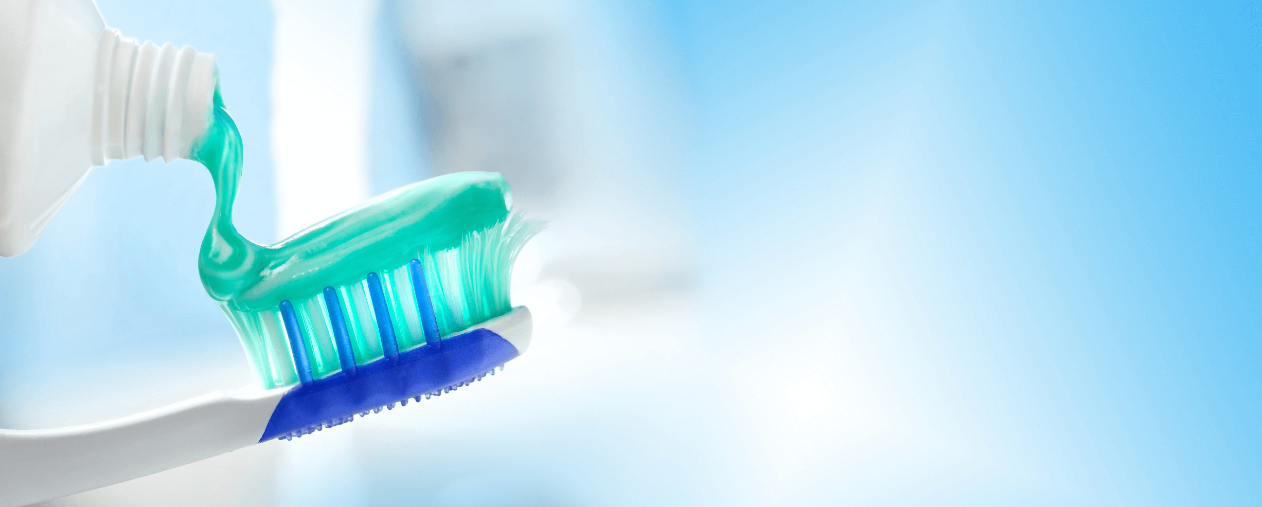 toothpaste being squeezed onto toothbrush
