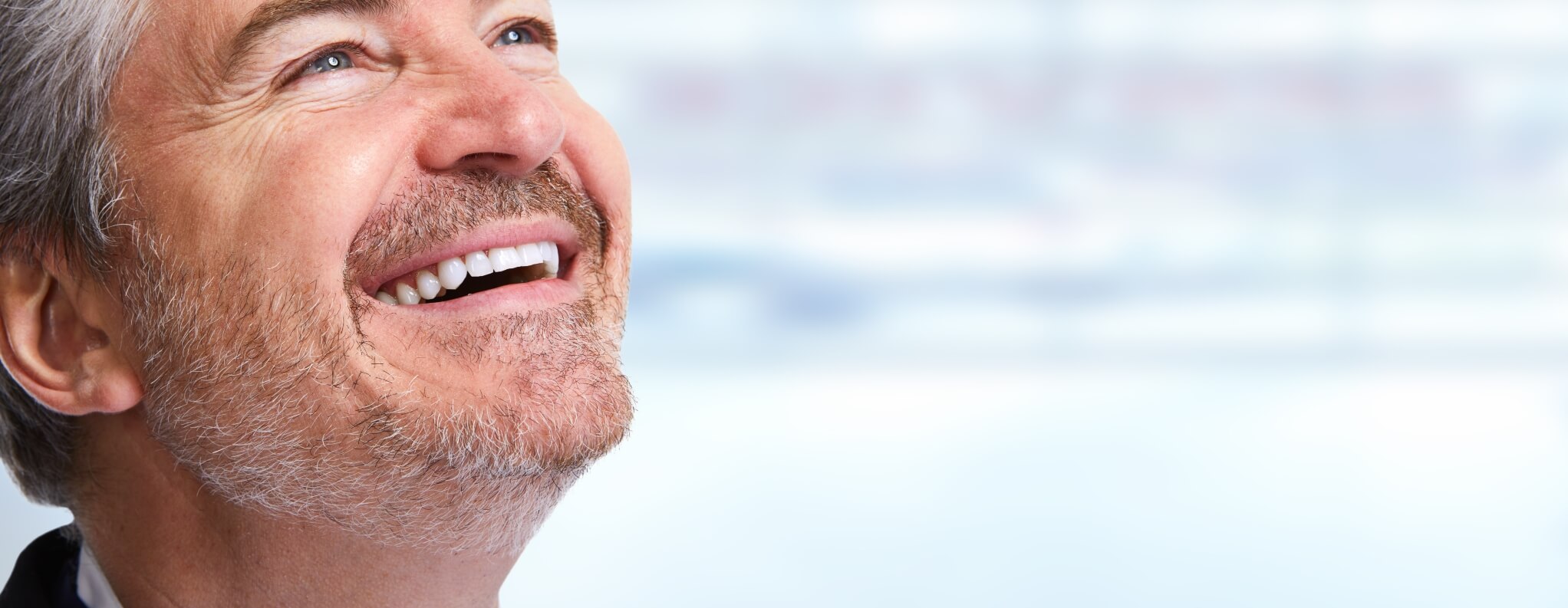 older man smiling looking up 