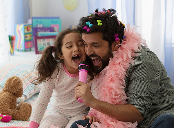 father and daughter singing on bed