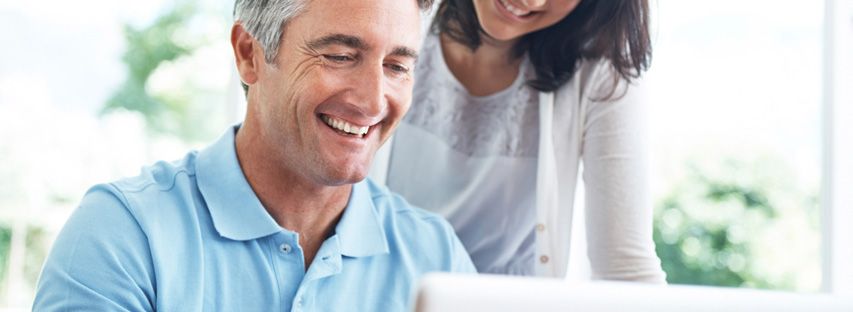 man looking at dental plan on laptop