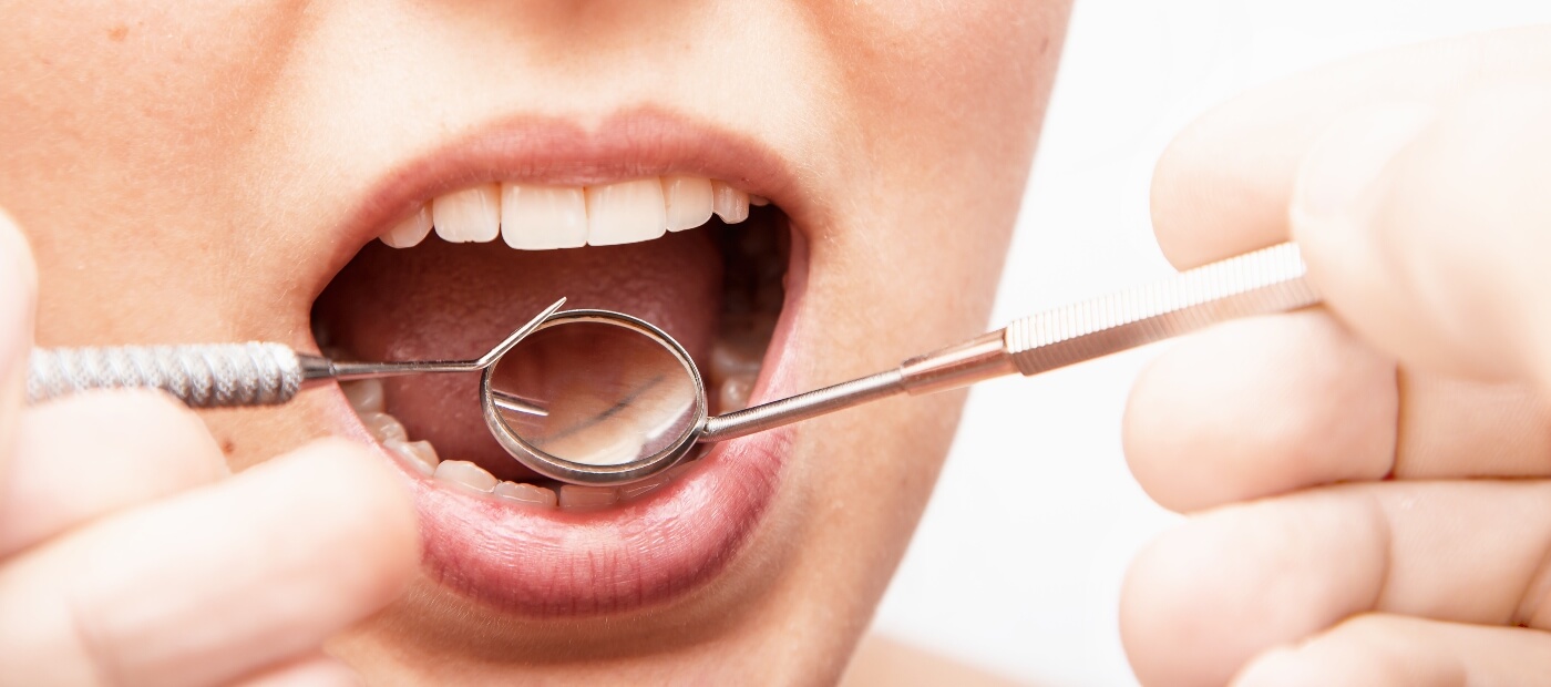woman getting plaque cleaned off of teeth