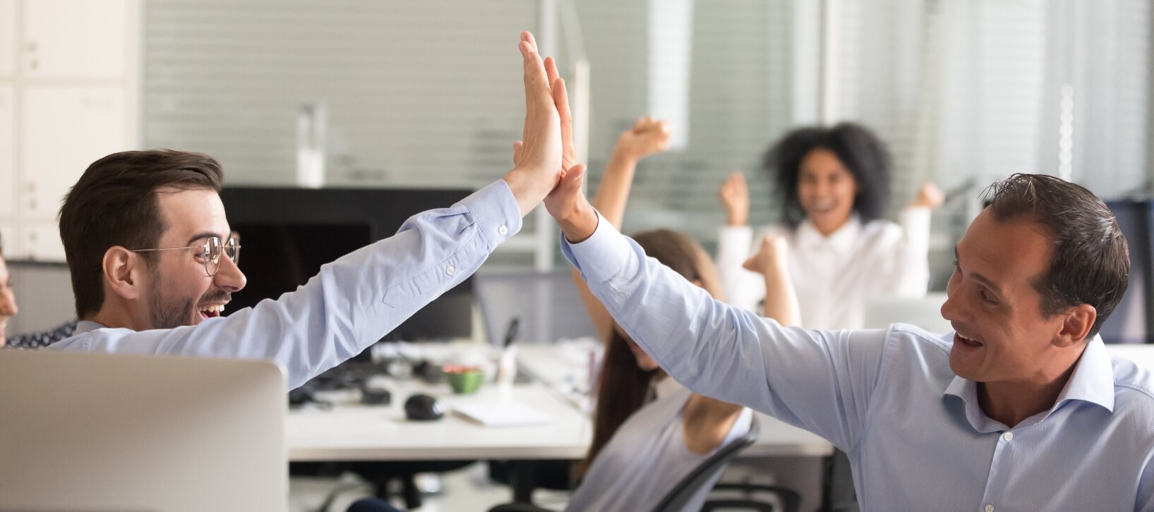 happy employees giving a high five to each other in the office
